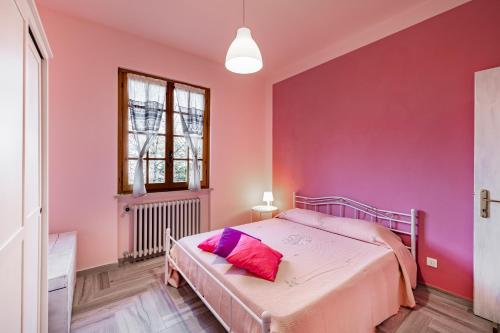 una camera rosa con letto e finestra di Comfortable Home Vittoria Among Greenery - Happy Rentals a Marliana