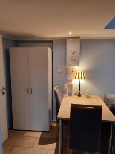 a kitchen with a table and a white cabinet at Münsterland Cottage in Lengerich