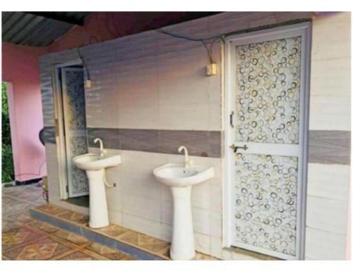 a bathroom with two sinks and a door at Madhuvan Homestay, Junagarh in Sasan Gir