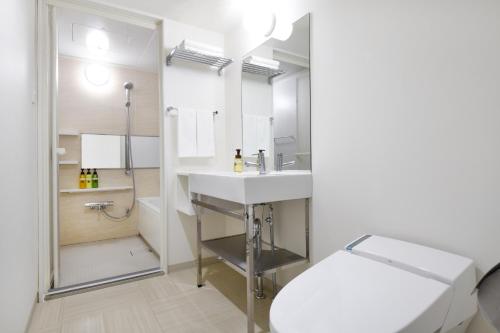 a bathroom with a sink and a toilet and a shower at HOTEL MYSTAYS Atsugi in Atsugi