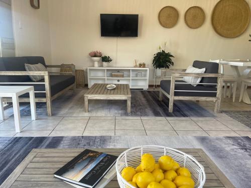 a living room with a bowl of lemons on a table at Footprints in Kleinmond in Kleinmond