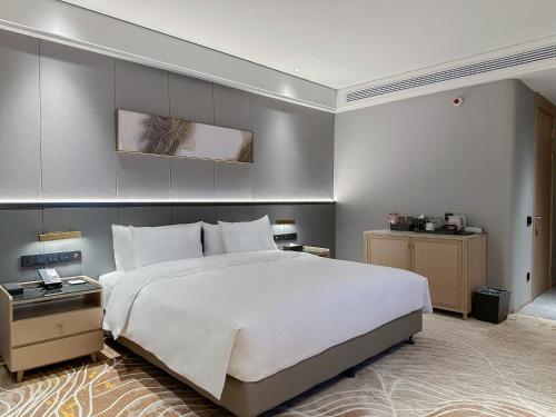 a large bedroom with a large white bed at Wanda Jin Jiamusi in Jiamusi
