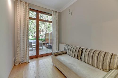 ein Wohnzimmer mit einem Sofa und einer Glasschiebetür in der Unterkunft Forest&Love - Neptun Park in Danzig
