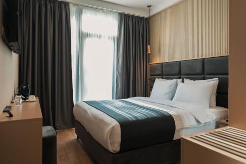 a hotel room with a bed and a window at Hotel Monday by DNT Group in Tbilisi City