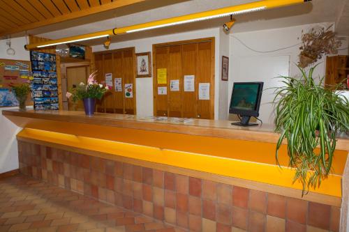 a lobby with a counter with a television on it at Village vacances de Valmeinier "Les Angeliers" in Valmeinier