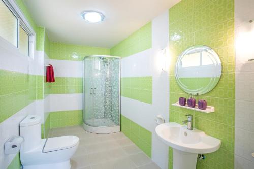 baño verde y blanco con aseo y lavamanos en Family 3BR Villa Platinum, Private Pool, Gated Residence, in middle of Naiharn and Rawai Beach, en Rawai Beach
