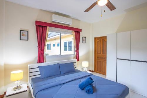 Un dormitorio con una cama azul y una ventana en Family 3BR Villa Platinum, Private Pool, Gated Residence, in middle of Naiharn and Rawai Beach, en Rawai Beach
