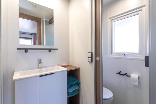 a bathroom with a sink and a mirror and a toilet at Mobilhome Soleia 2023 Mar Estan 4x in Canet-en-Roussillon