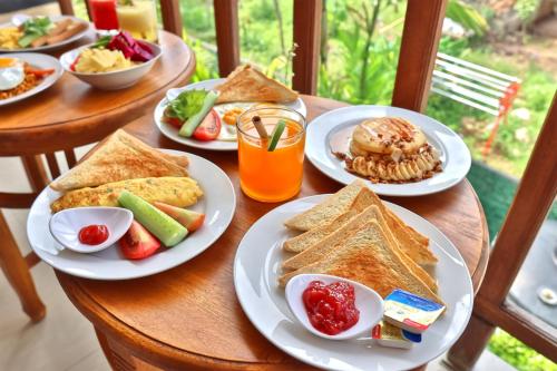 una mesa con platos de comida para el desayuno. en Ped Cottage, en Nusa Penida