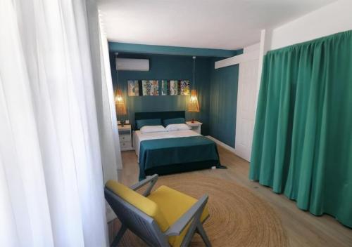 1 dormitorio con 1 cama y 1 silla en Les Cerisiers - Exclusive Beach Residence Flic en Flac, en Flic en Flac