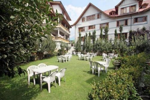 een groep tafels en stoelen in een tuin bij Hotel International Srinagar in Srinagar