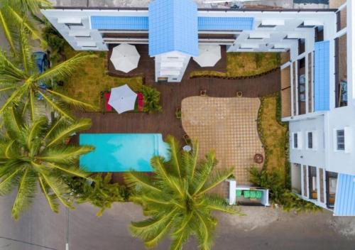una vista aérea de un edificio con piscina y palmeras en Les Cerisiers - Exclusive Beach Residence Flic en Flac, en Flic en Flac