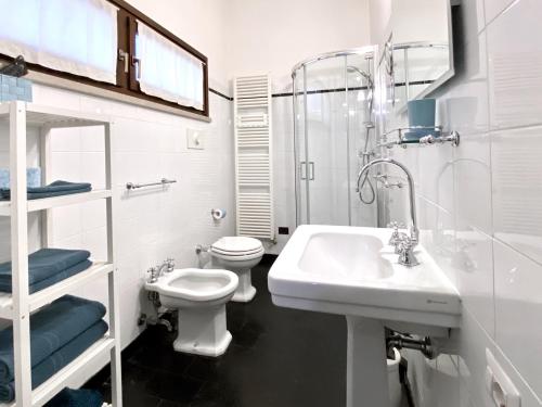 bagno bianco con lavandino e servizi igienici di Violino azul a Cremona