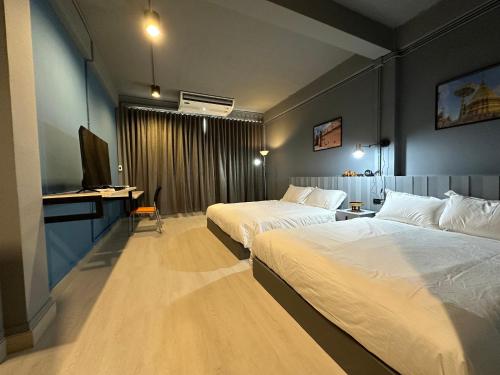 a hotel room with two beds and a television at Bangkok vibe, City House, 7 mins to BTS, City center, Private room in Sathon, Private bathroom, Bangkok, Thailand in Bangkok