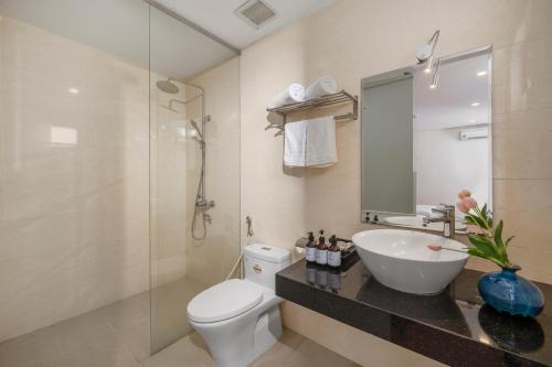 y baño con aseo, lavabo y ducha. en Bantique Hotel, en Da Nang