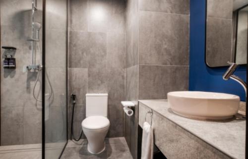 a bathroom with a sink and a toilet and a shower at Aston Serang Hotel & Convention Center in Serang