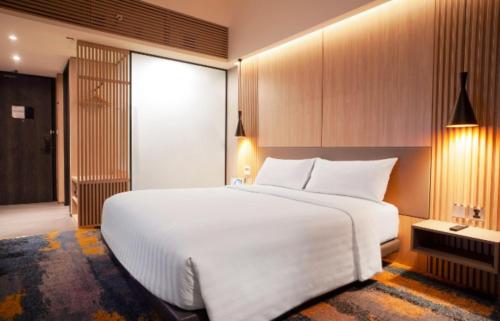 a bedroom with a large white bed in a room at Aston Serang Hotel & Convention Center in Serang