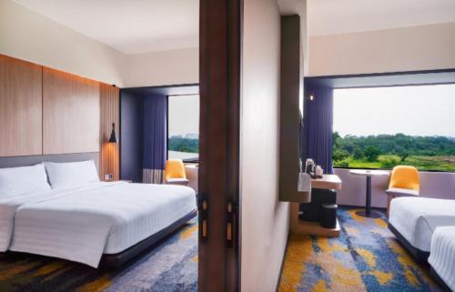 pokój hotelowy z 2 łóżkami i dużym oknem w obiekcie ASTON Serang Hotel & Convention Center w mieście Serang
