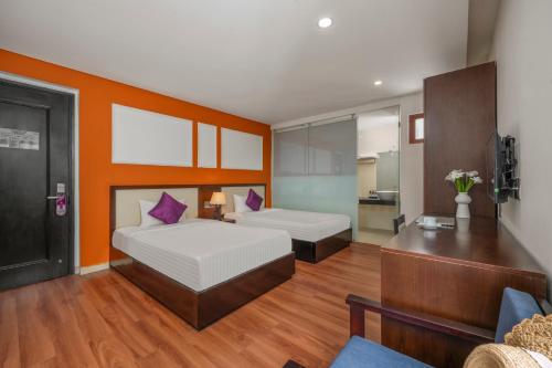 a bedroom with two beds and a couch at Bantique Hotel in Da Nang
