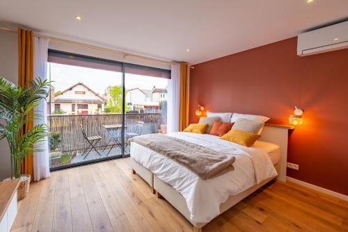 une chambre avec un grand lit et un balcon dans l'établissement Studio Eiffel, à Bagneux