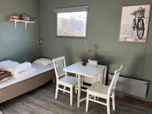 Habitación pequeña con cama, mesa y sillas en Borgane 5, en Fjällbacka