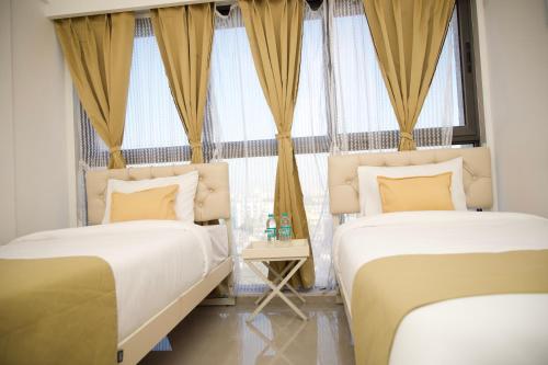 a bedroom with two beds and a window at Z Bliss Suites, BKC in Mumbai