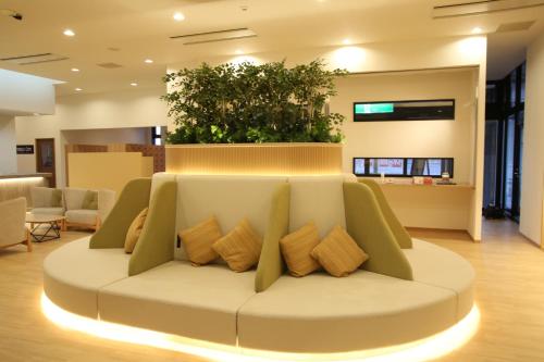 a living room with a white couch with pillows at Kojohama Onsen Hotel in Shiraoi