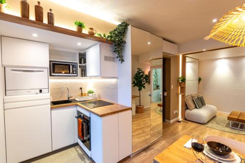 une cuisine avec des armoires blanches et un salon dans l'établissement Studio Garnier, à Bagneux