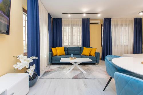 a living room with a blue couch and yellow pillows at Vitosha Downtown Apartments in Sofia