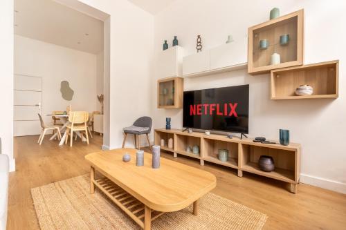 a living room with a tv and a table at Cosy T2 Charme confort - Cœur de Lille Sebastopol by Lity in Lille