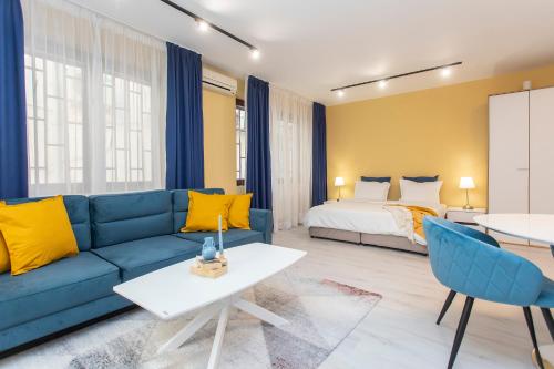 sala de estar con sofá azul y cama en Vitosha Downtown Apartments, en Sofía