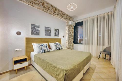 sypialnia z łóżkiem, krzesłem i oknem w obiekcie Horizon Studios - Apartments w mieście Rodakino