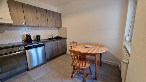 une petite cuisine avec une table et des chaises en bois dans l'établissement Appartement Le Grillenbreit, à Colmar