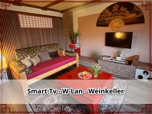 a living room with a couch and a tv at SmallSaigon Apartment mit guter Anbindung in Leiningen