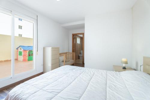 a bedroom with a large white bed and a window at Ca Vivi in Catarroja