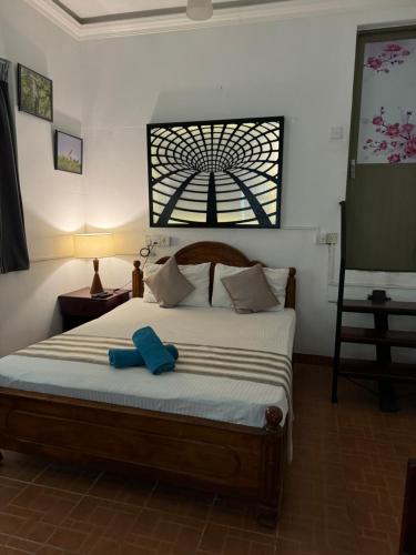 a bedroom with a bed with a blue object on it at Natures Bliss Holidays in Ja-Ela