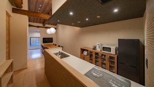 a kitchen with a sink and a refrigerator at UTAKATA HOTEL HIMEJI in Himeji
