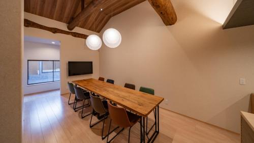 a dining room with a wooden table and chairs at UTAKATA HOTEL HIMEJI in Himeji