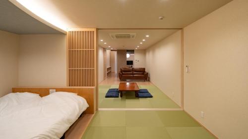 a bedroom with a bed and a couch and a table at UTAKATA HOTEL HIMEJI in Himeji