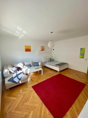 sala de estar con sofá y alfombra roja en City Retreat in Eisenstadt Zentrum, en Eisenstadt