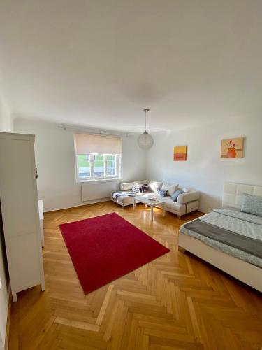 een woonkamer met een bed en een rood tapijt bij City Retreat in Eisenstadt Zentrum in Eisenstadt