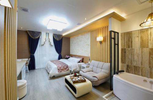 een badkamer met een bed en een bad en een slaapkamer bij Gentleman Hotel in Suncheon