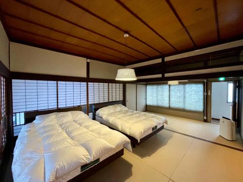 山口YudaOnsen Byakkoan　山口湯田温泉 白狐庵的有两张床和天花板的卧室
