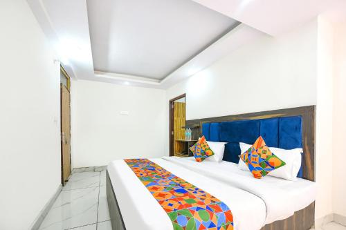 a bedroom with a large bed with colorful pillows at FabHotel Beer Castle in Shimla