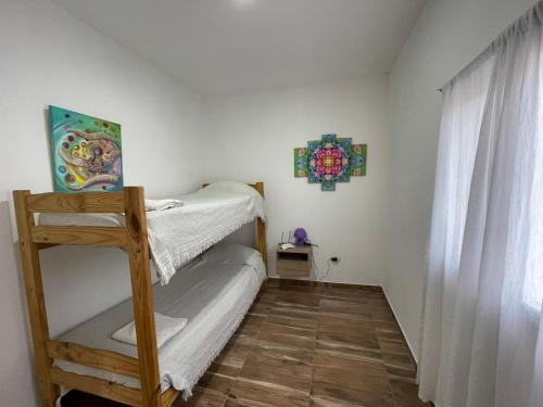 Dormitorio pequeño con litera y ventana en Los 4 elementos en San Marcos Sierras