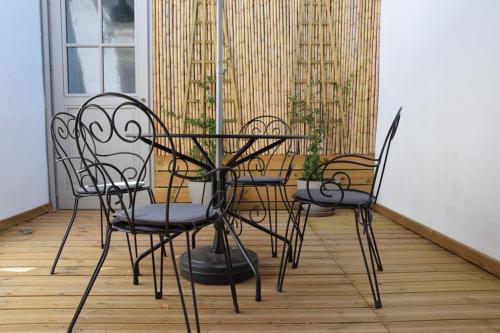 3 chaises et une table sur une terrasse couverte dans l'établissement Le ventoux 1912, à Bédoin
