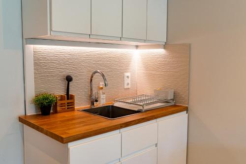 a kitchen with white cabinets and a sink at Studio Le Nôtre in Bagneux