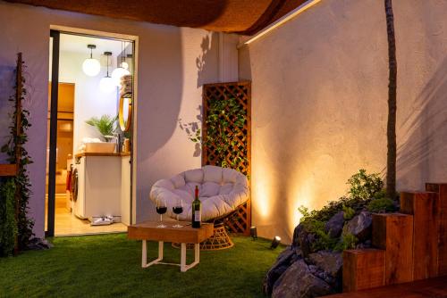 a room with a couch and a table with a bottle of wine at Studio Le Nôtre in Bagneux