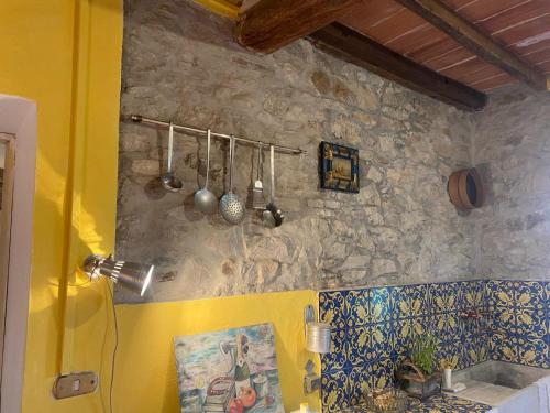 una cocina con una pared de piedra y utensilios. en Villa Chicca, en Neviano degli Arduini