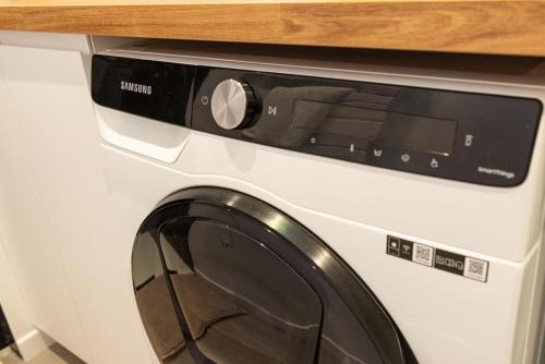 a white washing machine sitting under a counter at Studio Le Nôtre in Bagneux